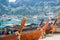 A lot of long tail boats on tropical beach. Moored in the port on the asian island