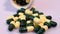 Lot of medical pills for treatment in yellow green capsules on a rotating table. Close-up of medicines, vitamins.