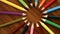 A lot of multicolored pencils revolve in a circle on a black wooden background. Concept office or school, knowledge day, the first