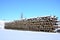 A lot of old rails and sleepers are stacked in a railway warehouse in winter. The concept of renewing a worn-out railway track