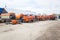 A lot of orange Kamaz trucks stands on the truck parking