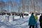 A lot of people crowd walking in the Park in winter with children on the street in the forest