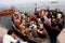 A lot of people sit on the crowded boats to cross the Ganges River