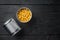 Lot of pieces of canned yellow corn in metall can, on black wooden table background, top view flat lay with copy space for text
