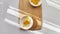 Lot of pieces of canned yellow corn on plate which is on wooden bamboo cutting board on white background. The concept of