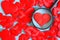 A lot of red hearts on a blue background. One of them is examined under a magnifying glass. The choice of a life partner or loved