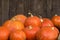 A lot of red ripe pumpkins on a old wooden background close up, holiday halloween. Pile of ripe pumpkins. Harvest autumn wallpaper