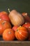 A lot of red ripe pumpkins on a old wooden green background close up, holiday halloween. Pile of ripe pumpkins. Harvest autumn