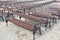 Lot of Rows of empty brown wooden benches