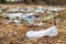 A lot of rubbish and plastic bags blown by the wind across the field