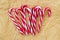 A lot of sweet caramel candy canes on a crumpled parchment paper. Tasty decorative attribute of Christmas and New Year