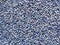 A lot of tiny ceramic balls or granules in color range from beige to dark blue as a background. Grainy or granular texture