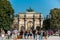 A lot of tourists in front of the Arc de Triomphe du Carrousel, situated at the entrance of Jardin de Tuileries, close to the