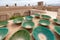 Lot of traditional green bowls on the roof of persian city. Clay bowls with rooftops of Yazd, Iran, in the background