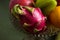 A lot of tropical fruits in a glass vase. Exotic fruits: averrhoa carambola, Pitahaya, Mango, Plantain, tangerines, pomegranate