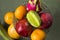 A lot of tropical fruits in a glass vase. Exotic fruits: averrhoa carambola, Pitahaya, Mango, Plantain, tangerines, pomegranate