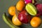 A lot of tropical fruits in a glass vase. Exotic fruits: averrhoa carambola, Pitahaya, Mango, Plantain, tangerines, pomegranate fr