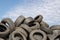 A lot of used tyres against blue sky with white clouds