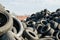 A lot of used tyres against roof of the house and blue sky with white clouds