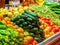 A lot of vegetables and fruits on market shelves, close up view. Cucumbers, tomatoes, peppers, apples. Fresh fruits and