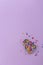 A lot of vibrant multicolored confectionery sprinkles placed in the baking dish in the form of an Easter chick on lilac background