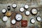 A lot of vintage clocks of different sizes hanging on a grunge brick wall. Round and square clocks show different time