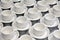 Lot of white porcelain tea pairs in piles in a straight line. Co