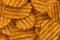 Lot of whole rippled potato chips as abstract background.