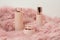 Lotion bottles are beautifully arranged on a pink feather cloth.