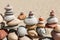 Lots of balanced, colorful pebbles on a beach on the background of the sand