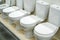 Lots of ceramic toilets in a plumbing store. Trade in equipment for bathrooms. Close-up