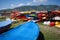 Lots of colorful plastic kayaks lie on storage shelves against mountains on shores of Mediterranean Sea