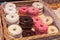 Lots of doughnuts close up on in a wooden box on the counter at the bakery. fresh, delicious pastries