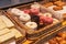 Lots of doughnuts close up on in a wooden box on the counter at the bakery. fresh, delicious pastries