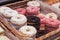 Lots of doughnuts close up on in a wooden box on the counter at the bakery. fresh, delicious pastries