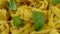 Lots of dry tagliatelle pasta, garnished with basil leaves , rotate of circle counterclockwise. Close-up.