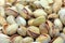 Lots of fried pistachios . On a white background in the plate is a lot of cooked pistachios as the background