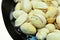 Lots of fried pistachios . On a white background in the plate is a lot of cooked pistachios as the background