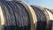 Lots of huge wooden spools with a thick cable under the open sky on the territory of the cable plant.