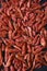 Lots of red delicious shrimp as background. Appetizer of dried peppered shrimp on a black background. The appetizer is salty with