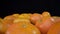 Lots of ripe tangerines shot in extreme detailed macro forward movement. On a black background