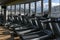 Lots of running machines near panoramic window in gym. Empty treadmills in the fitness club