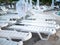 Lots of white empty sun loungers at the pool closeup at sunset