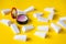 Lots of white triangular sponges and lip gloss on a yellow background