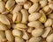 Lots of whole and cracked pistachio nuts. Close-up. High angle view. Delicious healthy product. Cafe, restaurant, pastry shop,
