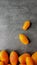 Lots yellow stretched long-fruited tomatoes on a gray stone background