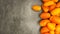 Lots yellow stretched long-fruited tomatoes on a gray stone background