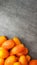 Lots yellow stretched long-fruited tomatoes on a gray stone background