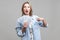 Lottery winner. Portrait of amazed beautiful woman pointing at fan of dollars. indoor studio shot isolated on gray background