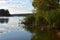 ?louds above the forest lake at sunset. Symmetry reflections on the water